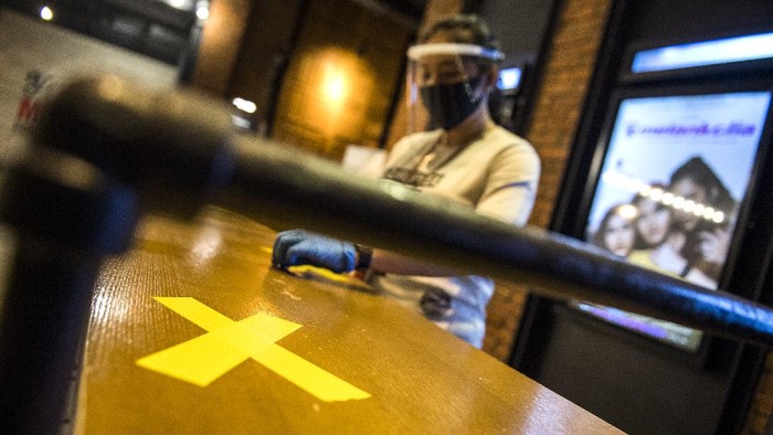 Pekerja memasang tanda jaga jarak saat simulasi pembukaan dan peninjauan tempat hiburan bioskop CGV Cinemas di Bandung Electronic Center (BEC), Bandung, Jawa Barat, Kamis (9/7/2020). Simulasi tersebut dilakukan dalam rangka peninjauan kesiapan tempat hiburan bioskop dalam penerapan protokol kesehatan seperti penggunaan alat pelindung wajah bagi karyawan, pembatas jaga jarak, masker, sarung tangan dan cairan disinfektan seiring tatanan normal baru di tengah pandemi COVID-19. ANTARA FOTO/M Agung Rajasa/aww.