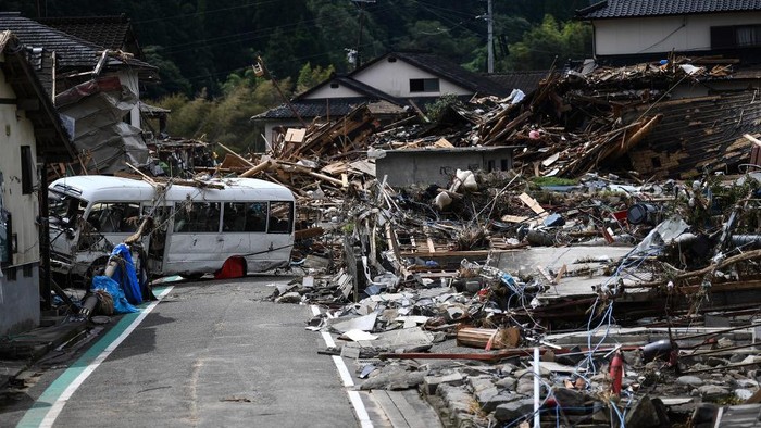 Debris litter a village following heavy rains and flooding in the village of Kuma, Kumamoto prefecture on July 8, 2020. - Japan will deploy more troops to search for survivors of devastating floods and landslides that have killed at least 52 people in the southwest of the country, Prime Minister Shinzo Abe pledged (Photo by CHARLY TRIBALLEAU / AFP) / The erroneous mention[s] appearing in the metadata of this photo by CHARLY TRIBALLEAU has been modified in AFP systems in the following manner: [Kumamura] instead of [Kuma mura]. Please immediately remove the erroneous mention[s] from all your online services and delete it (them) from your servers. If you have been authorized by AFP to distribute it (them) to third parties, please ensure that the same actions are carried out by them. Failure to promptly comply with these instructions will entail liability on your part for any continued or post notification usage. Therefore we thank you very much for all your attention and prompt action. We are sorry for the inconvenience this notification may cause and remain at your disposal for any further information you may require.