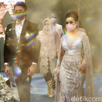 Di era new normal, para pengantin yang menggelar resepsi pernikahan diwajibkan untuk mengenakan masker guna mencegah penyebaran virus Corona.