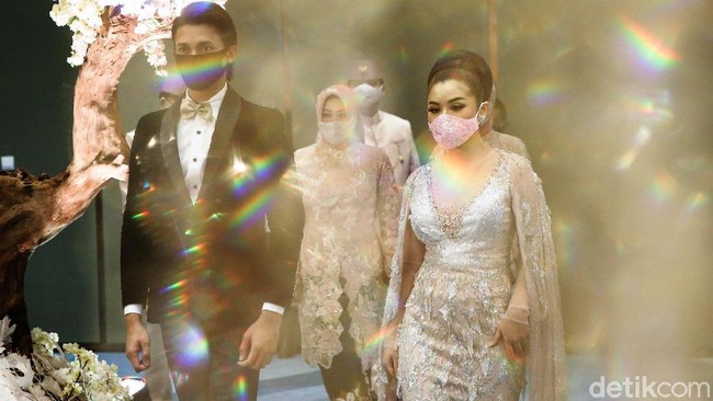 Di era new normal, para pengantin yang menggelar resepsi pernikahan diwajibkan untuk mengenakan masker guna mencegah penyebaran virus Corona.