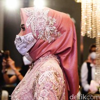 Para tamu undangan pun diwajibkan mengenakan masker saat akan menghadiri resepsi pernikahan di era new normal tersebut.