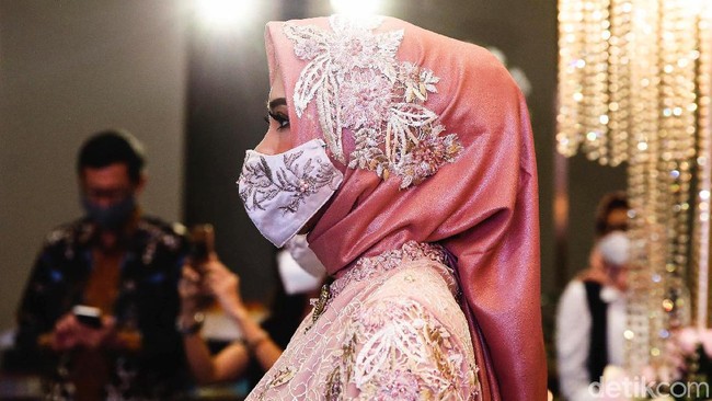 Para tamu undangan pun diwajibkan mengenakan masker saat akan menghadiri resepsi pernikahan di era new normal tersebut.