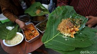 Nasi Berkat itu tak dibungkus di dalam wadah plastik maupun styrofoam melainkan dibungkus dengan daun Jati.