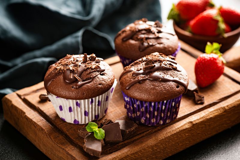 Chocolate muffins on wooden board. Sweet food. Tasty chocolate cakes