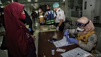 Sejumlah petugas otoritas dan kesehatan pelabuhan memeriksa kesehatan serta kelengkapan dokumen penumpang.