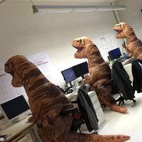 Kalau kamu menemukan yang seperti ini di ruang kerjamu, kira-kira apa yang akan kamu lakukan? Bukan patung, tapi ini adalah foto karyawan yang sedang merayakan Halloween dengan menggunakan kostum dinosaurus. Foto: dok. Reddit