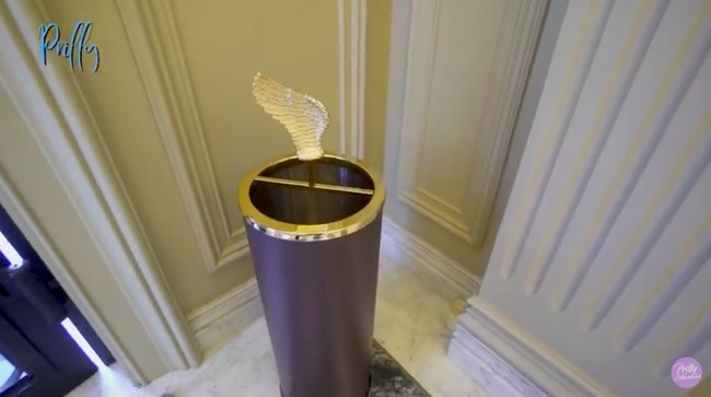 Di salah satu sudut foyer, terdapat sebuah tempat payung berhiaskan sayap mengilap di atasnya yang tampak seperti sebuah instalasi seni. Ini jangan salah guys, ini tempat payung. Tempatnya dipilih secara khusus, mewah banget, kata Prilly. (Foto: YouTube/Prilly Latuconsina)