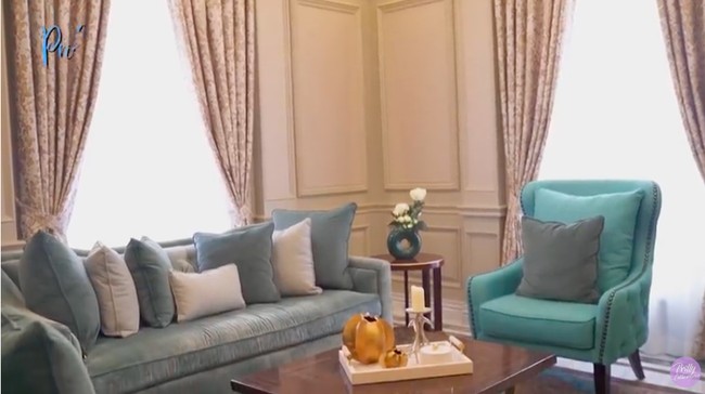 Ruang tamu hadir dalam konsep desain semi formal dalam kombinasi paneling bergaya klasik yang dikontraskan dengan furniture modern berwarna biru dan beige nan glamor. (Foto: YouTube/Prilly Latuconsina)