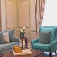 Ruang tamu hadir dalam konsep desain semi formal dalam kombinasi paneling bergaya klasik yang dikontraskan dengan furniture modern berwarna biru dan beige nan glamor. (Foto: YouTube/Prilly Latuconsina)
