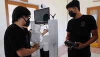 Mahasiswa memeriksa tekanan darah dengan menggunakan robot rakitan saat melakukan uji coba di ruang Unit Kegiatan Mahasiswa (UKM) Robotec Universitas Udayana, Denpasar, Bali, Jumat (10/7/2020).   
