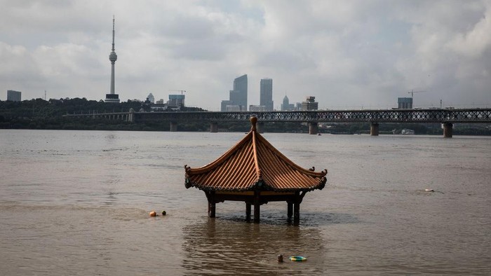 Wuhan Diterjang Banjir WUHAN, CHINA - JULY 09: (CHINA OUT) A resident swims in flooded waters at Jiangtan Park caused by heavy rain along the Yangtze river on July 9, 2020 in Wuhan, China. On July 5, Wuhan upgraded its emergency response for flood control from Grade III to Grade II, the second-highest of the four-tier system following weeks of torrential rain which have reportedly left at least 121 dead or missing. (Photo by Getty Images)
