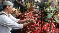 Pihak keluarga melepas seekor ayam jantan di atas makam Yodi Prabowo.