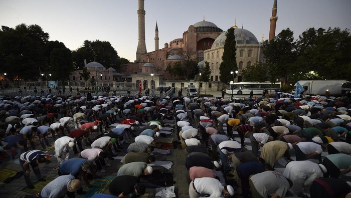 Muslims offer their evening prayers outside the Byzantine-era Hagia Sophia, one of Istanbuls main tourist attractions in the historic Sultanahmet district of Istanbul, following Turkeys Council of States decision, Friday, July 10, 2020. Turkeys highest administrative court issued a ruling Friday that paves the way for the government to convert Hagia Sophia - a former cathedral-turned-mosque that now serves as a museum - back into a Muslim house of worship. The Council of State threw its weight behind a petition brought by a religious group and annulled a 1934 cabinet decision that changed the 6th century building into a museum.