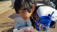 Jalan-jalan ke Universal Studios yang di Florida, Nino pasang pose imut saat ngemil donat berukuran besar dengan minuman dingin. Foto: Instagram @nino_kuya