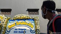Para pelayat yang datang nampak melihat dan sesekali berhenti sejenak untuk membaca tulisan di karangan bunga.