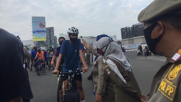 Suhu tubuh warga diperiksa sebelum diizinkan memasuki kawasan CFD di Jalan Jend Ahmad Yani, Kota Bekasi, MInggu (12/7/2020).