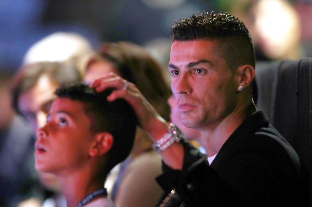 LONDON, ENGLAND - NOVEMBER 12:  Cristiano Ronaldo and son Cristiano Ronaldo Jr. watch on during the singles round robin match between Novak Djokovic of Serbia and John Isner of The United States during Day Two of the Nitto ATP Finals at The O2 Arena on November 12, 2018 in London, England.  (Photo by Naomi Baker/Getty Images)