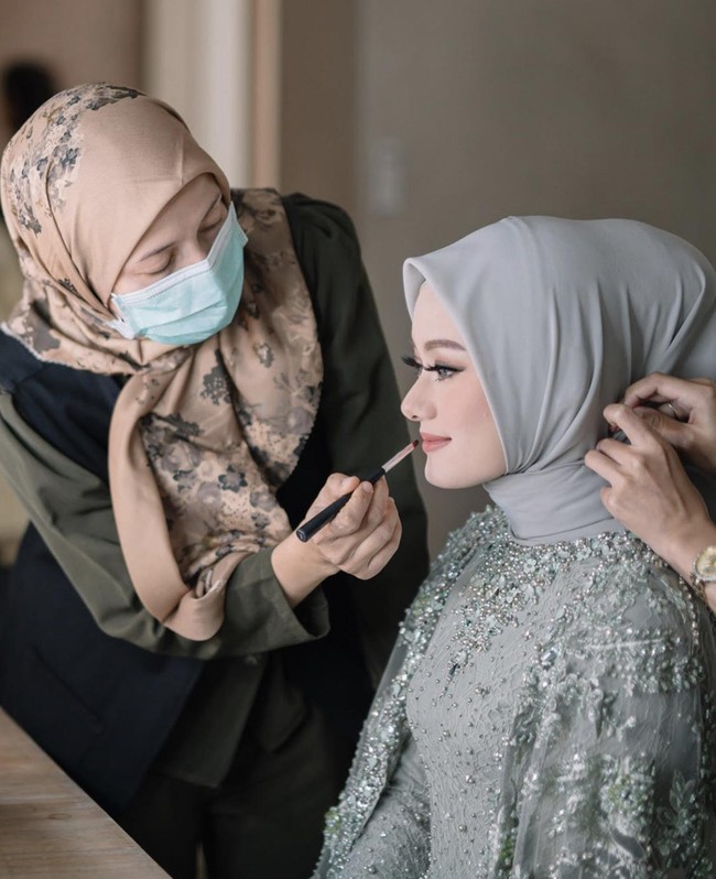 Hijab stylist Awanis Arifiani membuat Dinda Hauw tampil dengan gaya hijab simpel saat lamaran. Hal itu agar memperlihatkan detail cantik pada kebaya bagian leher terlihat. Hijab yang digunakan adalah bahan chiffon atau ceruti yang diikat rapi ke belakang dengan menggukan inner hijab agar rambut belakang terlihat mengembang. Foto: Instagram @imagenic.