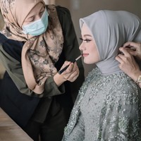 Hijab stylist Awanis Arifiani membuat Dinda Hauw tampil dengan gaya hijab simpel saat lamaran. Hal itu agar memperlihatkan detail cantik pada kebaya bagian leher terlihat. Hijab yang digunakan adalah bahan chiffon atau ceruti yang diikat rapi ke belakang dengan menggukan inner hijab agar rambut belakang terlihat mengembang. Foto: Instagram @imagenic.