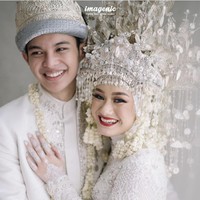 Tiba saat akad nikah pada Jumat (10/7/2020), Dinda Hauw dan Rey Mbayang  mengenakan busana pengantin adat Palembang bernuansa putih. Dinda menggunakan mahkota aesan paksangko, yang juga dihiasi kembang goyang di bagian kepala, kembang kenango, kelapo standan, dan lain-lain. Setelah acara pernikahan ini, pasangan pengantin baru tersebut sempat viral karena pengakuan Dinda yang tak bisa masak mie instant. Foto: Instagram @imagenic.
