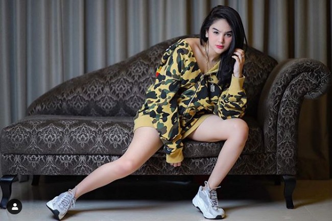 Sneakers sering menjadi andalan Hana Hanifah untuk bergaya saat difoto. Seperti di foto ini, Hana berpose memakai sneakers yang diklaimnya merek Yeezy dari Kanye West. Dia juga mengenakan jaket dari brand Jepang, A Bathing Ape atau BAPE. Foto: Instagram @ hanaaaast