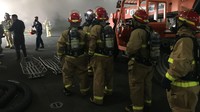 Petugas bahu-membahu untuk memadamkan api yang membakar kapal perang tersebut. Petty Officer 1st Class Jason Kofonow/US Navy via AP.
