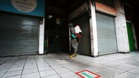 Petugas melakukan penyemprotan disinfektan di Pasar Pramuka, Jakarta, Senin (13/7).