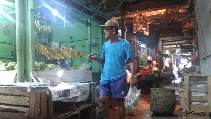 Pegunjung sedang menenteng kantong plastik berisi belanjaannya di Pasar Cempaka Putih, Jakarta Pusat, Jumat (28/02/2020). (ANTARA/Mochamad Firdaus)