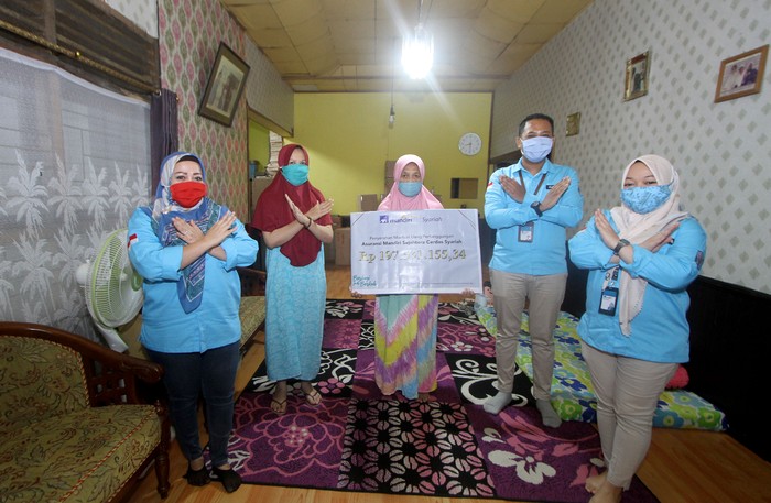 Pencairan Klaim Asuransi AXA Mandiri Perwakilan PT AXA Mandiri Financial Services (AXA Mandiri) Rini (dua kiri) menyerahkan pembayaran klaim asuransi jiwa secara simbolis kepada ahli waris nasabah AXA Mandiri Amaliah (dua kanan) di Banjarmasin, Kalimantan Selatan. Melalui manfaat perlindungan asuransi jiwa tersebut, keluarga yang ditinggalkan dapat terbantu secara finansial untuk terus melanjutkan hidup, ketika tulang punggung keluarga tutup usia. AXA Mandiri telah menyediakan perlindungan asuransi kepada lebih dari satu juta nasabah, serta telah membayarkan klaim dan maanfaat sebesar Rp 5,3 triliun pada tahun 2019 lalu. dok. AXA Mandiri