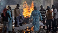 Kerabat mempersiapkan pembakaran untuk kremasi seseorang yang meninggal karena Corona di krematorium di New Delhi, India.