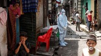 Seorang pekerja kesehatan menunggu warga untuk melakukan test Corona di daerah kumuh di Mumbai, India.