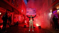 Seorang PSK di Hamburg, Jerman, membentangkan poster berisikan protes imbas masih ditutupnya lokalisasi distrik lampu merah.