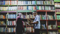 Guru di SMPN 153 Jakarta tengah membagikan buku pelajaran kepada orang tua siswa, Jakarta, Senin (13/7/2020). 