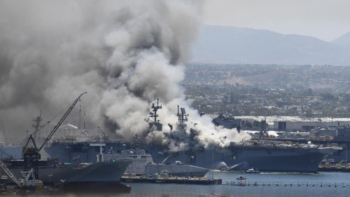 Smoke rises from the USS Bonhomme Richard at Naval Base San Diego Sunday, July 12, 2020, in San Diego after an explosion and fire Sunday on board the ship at Naval Base San Diego. (AP Photo/Denis Poroy)