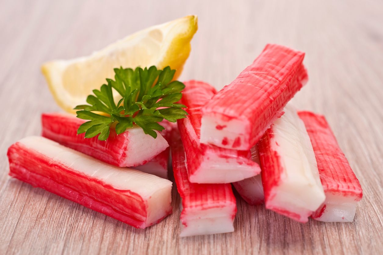 Salad crab sticks in a plate on a white table