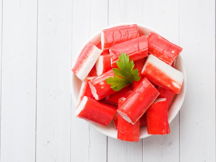 Salad crab sticks in a plate on a white table
