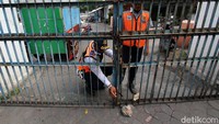 Petugas menggembok pintu masuk alun-alun.