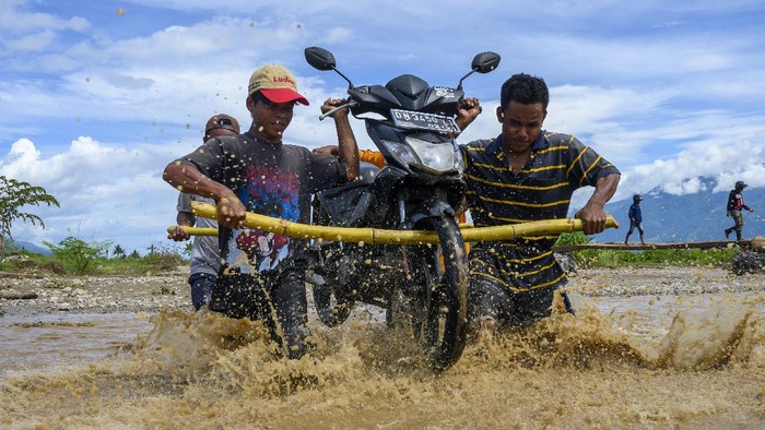 Banjir yang melanda desa di Kabupaten Sigi, Sulteng, ciptakan lapangan usaha baru bagi warga setempat. Mereka menyediakan jasa panggul untuk seberangkan motor.