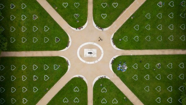 Pandangan udara dari Queen Square, di Bristol, Inggris. Tanda-tanda berbentuk hati dibuat di rumput untuk menjaga jarak sosial.  