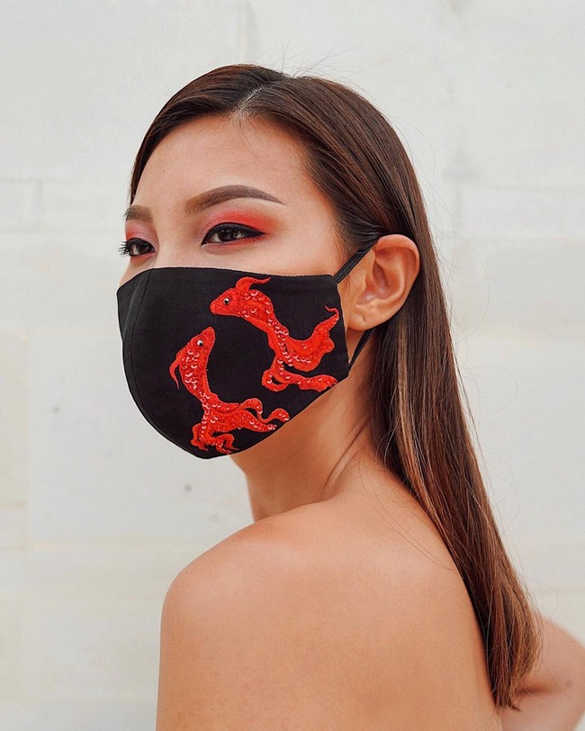 Masker yang membungkus wajah Patricia Gouw ini merupakan karya Hian Tjen. Masker berwarna hitam ini dihiasi motif ikan koi berwarna merah yang kontras. Leave the surgical masks and N95s for the healthcare professionals and essential workers, tulis Hian Tjen di Instagram saat mempromosikan maskernya. (Foto: Instagram/@hiantjen)