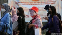 Para penumpang menerapkan protokol kesehatan dengan memakai masker dan face shield.