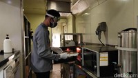 Prama bertugas untuk memanaskan makanan ke dalam microwave. (Bonauli/detikcom)