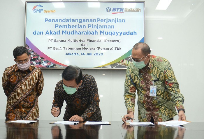 Direktur Utama PT Bank Tabungan Negara (Persero) Tbk, Pahala N. Mansury  bersama  Direktur Finance, Planning & Treasury Bank BTN Nixon L.P Napitupulu (kiri), Direktur Utama PT Sarana Multigriya Finansial (Persero)  Ananta Wiyogo (kedua kanan) dan Direktur SMF Heliantopo (kanan) menunjukkan Perjanjian Kerjasama (PKS) terkait pinjaman sebesar Rp 850 miliar di Jakarta, Selasa (14/7). Dana tersebut  akan disalurkan Bank BTN  dalam bentuk KPR Subsidi baik dengan skema Fasilitas Likuiditas Pembiayaan Perumahan atau FLPP maupun Subsidi Selisih Bunga (SSB) untuk mendukung Program Sejuta Rumah yang dicanangkan Pemerintah.
