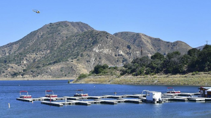Third boat from left, cordoned off with police tape, is believed to be the boat actress Naya Rivera and her son rented on July 8 as the search for her body continues at Lake Piru in the Los Padres National Forest, Ventura County, California on July 9, 2020. - 