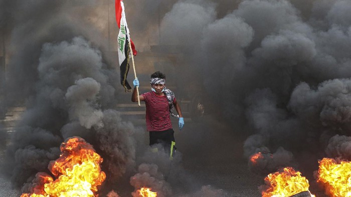 Protesters burn tires in front of the provincial council building during a demonstration demanding better public services and jobs and against corruption in Basra, southeast of Baghdad, Iraq, Tuesday, July 14, 2020. (AP Photo/Nabil al-Jurani)