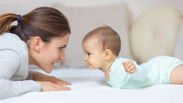 Ilustrasi Bayi Mother and 7 months old baby doing exercises on the bed and learning to crawl