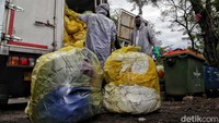 Sejumlah petugas Dinas Lingkungan Hidup dan petugas PT Wastec Internasional mengangkut limbah medis di Dipo Ancol, Jakarta Utara, Rabu (15/7/2020).