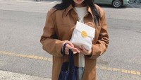 Sehabis membeli camilan, Park Gyu Young terlihat berpose di pinggir jalan dengan sebungkus makanan yang ia beli. Foto: Instagram @lavieenbluu
