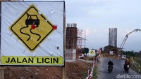 Pengendara sepeda motor melintas di samping proyek Kereta Cepat Jakarta Bandung.