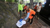 Para pelanggar PSBB juga harus memunguti sampah di atas trotoar.